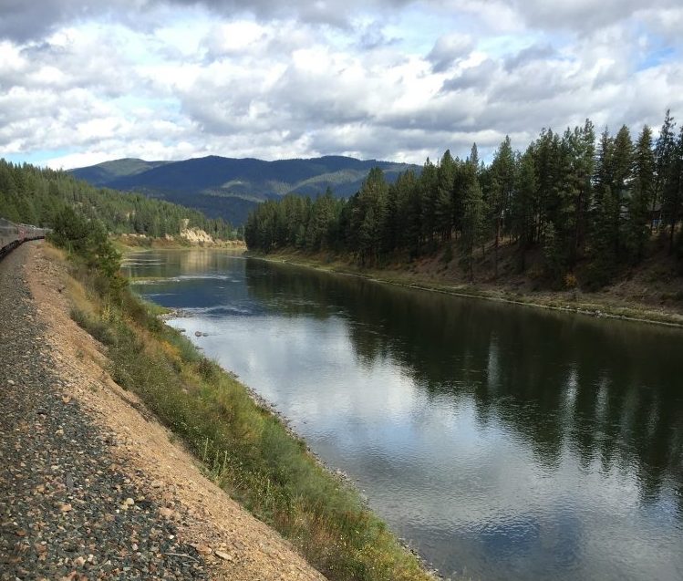 Private rail cars making their way down the Clark Fork River past the Rocky Mountains