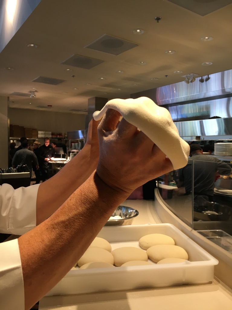 Then expand the dough by moving the knuckles of your hands underneath in a circular manner
