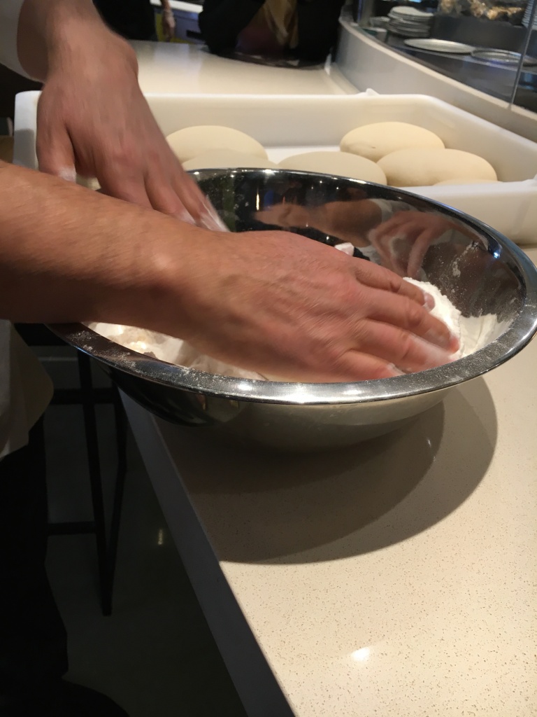 First take the dough and dip it in flour